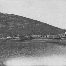 Аэродром в бухте Нагаево. На берегу строящиеся кунгасы и баржи морского типа. У берега - летающая лодка «Dorner-Wal» Н-1. 1933 год
