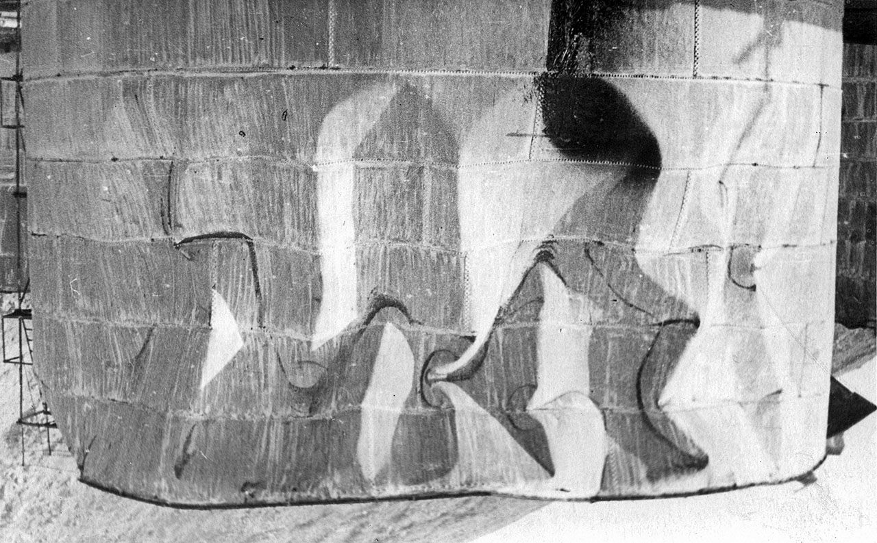 Искорёженная взрывной волной обшивка хранилища ГСМ на нефтебазе. Магаданский торговый порт. Последствия взрывов пароходов 19 декабря 1947 года.